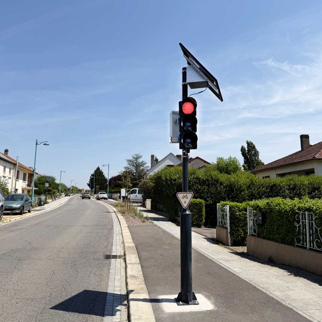 Feu comportemental au rouge installé sur une route avec panneau solaire et panneau M12f pour cyclistes